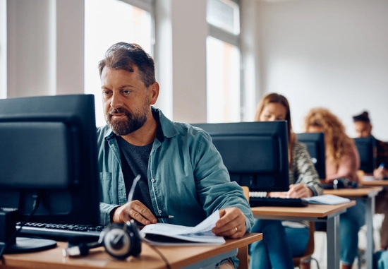 People looking at computers at individual tables