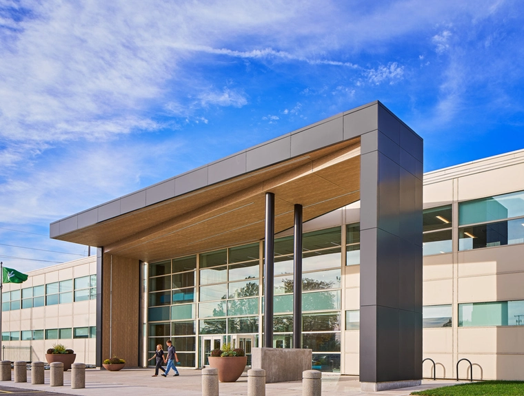 front of a campus building with many windows and a large awning