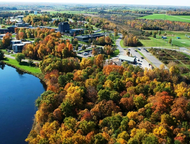 College campus next to a river with the tress changing colors for fall.