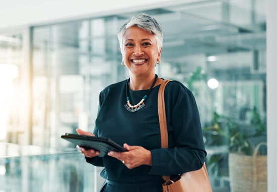 A women holding a tablet in a modern office smiling