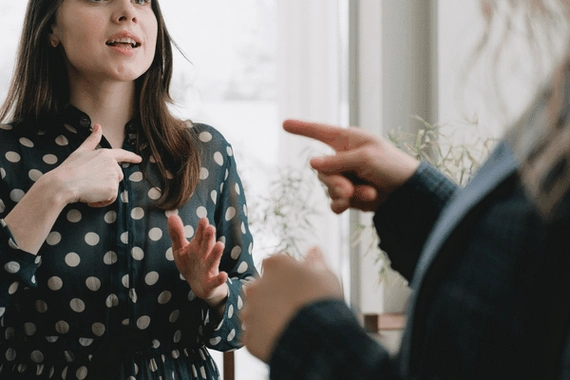 Two people are arguing. One is pointing their finger at the other.