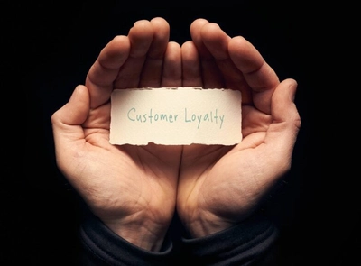 Hands holding a piece of paper that says, "Customer Loyalty".